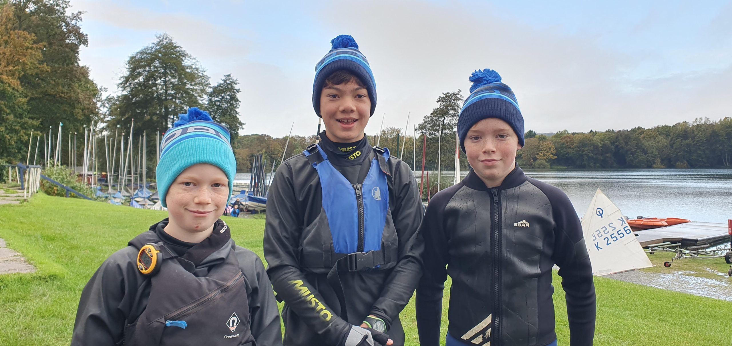 Three boys wearing Rooster bobble hats before the start of the Young Guns races.